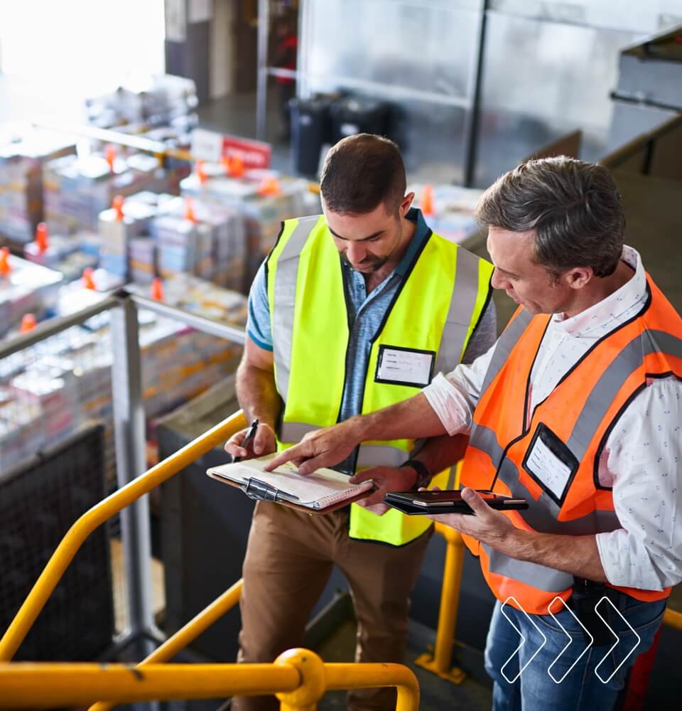 Employee double-checking the shipping schedule in a busy office environment.
